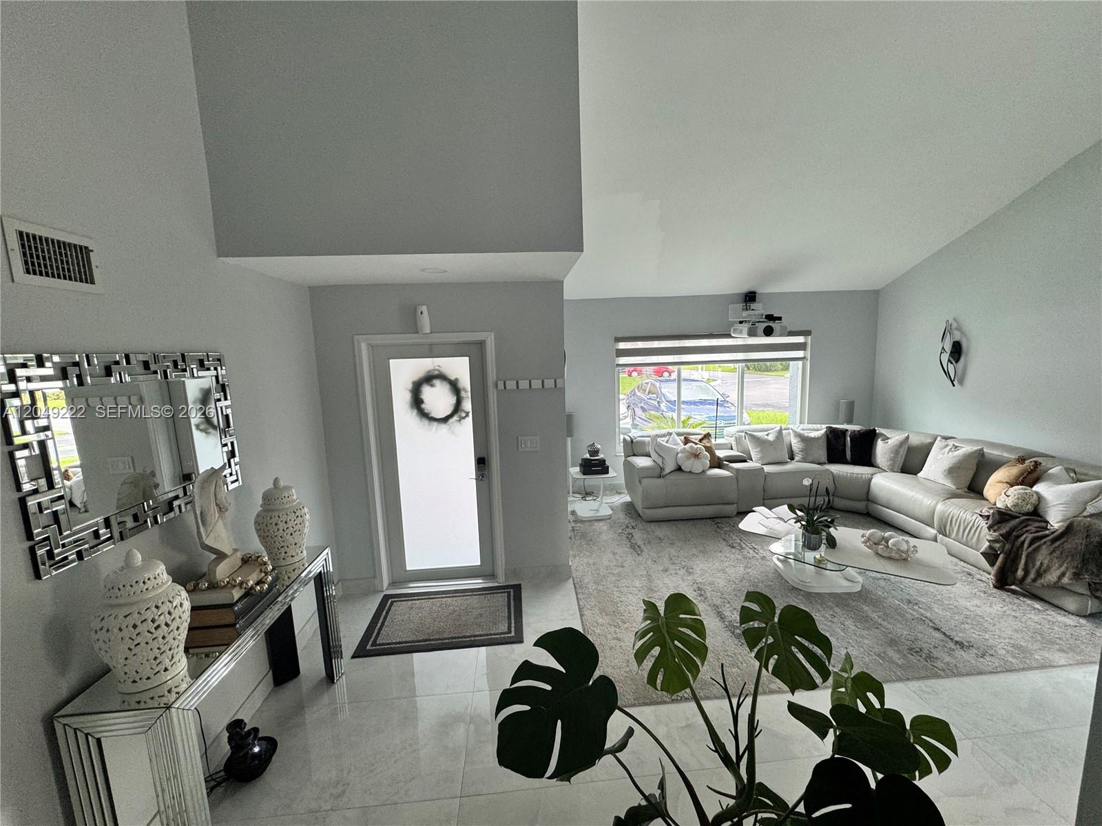 A living room features a white sectional sofa, tiled floors, and a mirrored console table — 9368 SW 146th Pl # 0, Miami FL 33186, MIAMI, FL