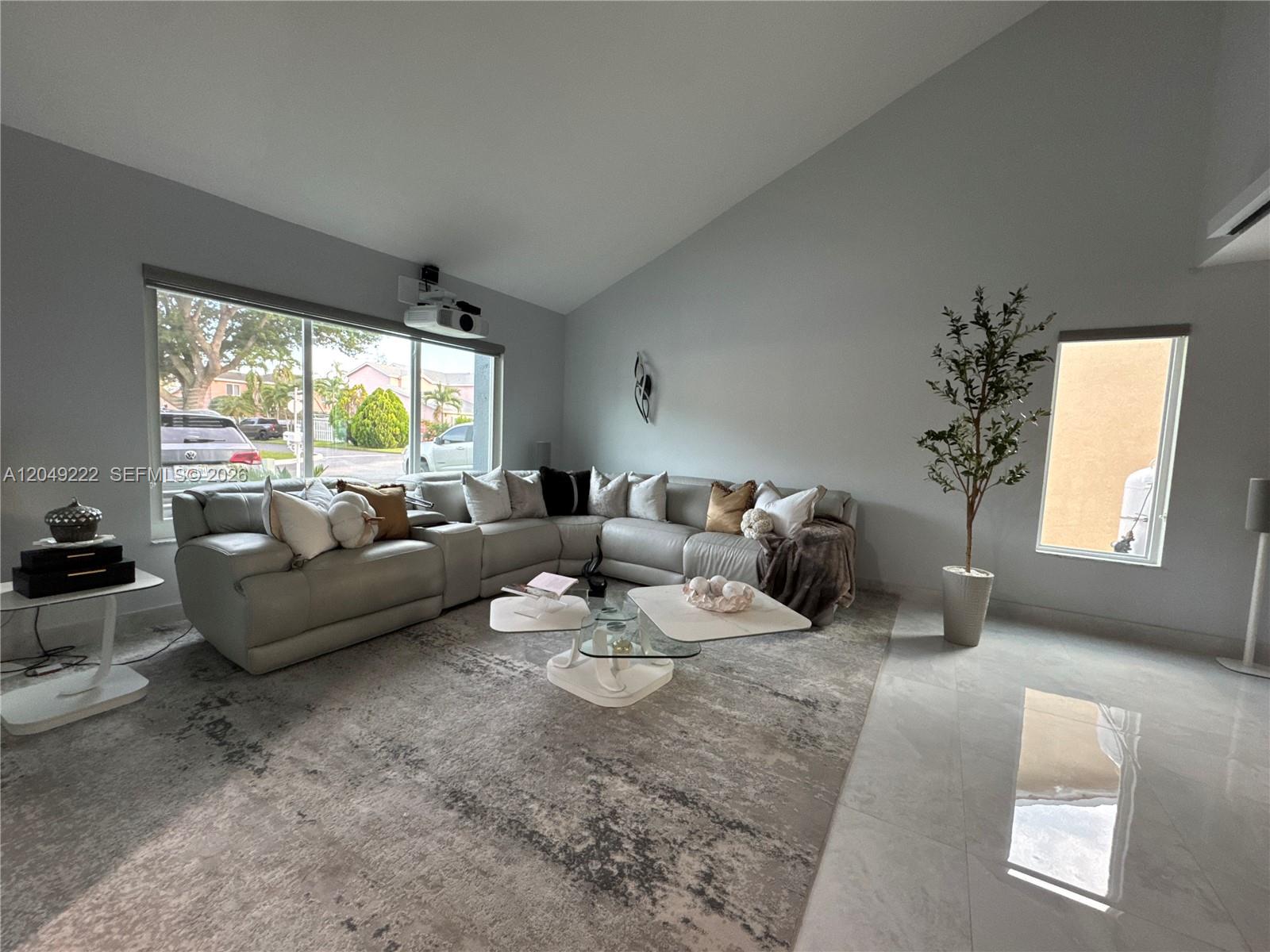 A living room features a large sectional sofa, a multi-tiered coffee table, and a projector — 9368 SW 146th Pl # 0, Miami FL 33186, MIAMI, FL
