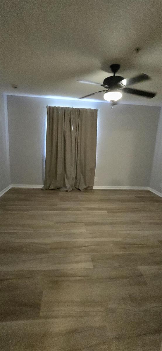 An empty room features light-colored wood-look flooring, gray walls, and a ceiling fan — 5357 SE Jennings Lane, Stuart FL 34997, STUART, FL