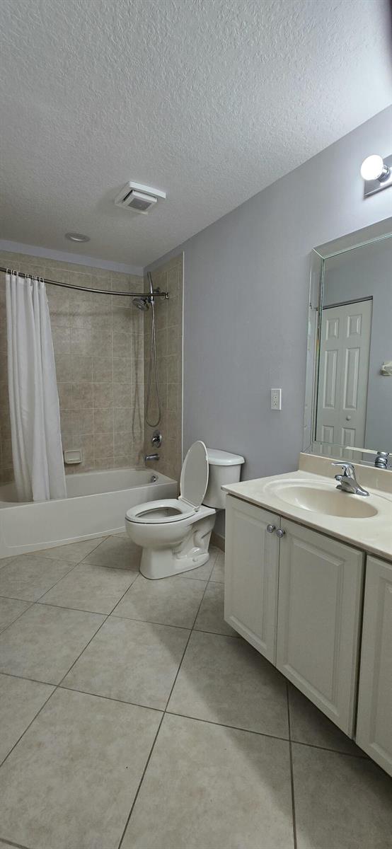 A bathroom with a tiled shower-tub combination, a white vanity, and a toilet — 5357 SE Jennings Lane, Stuart FL 34997, STUART, FL
