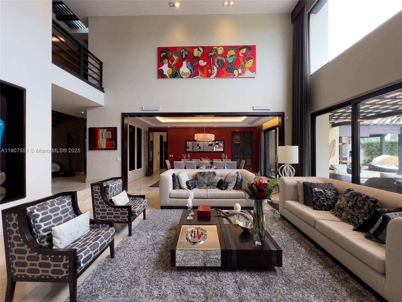 A spacious living room features high ceilings, modern furniture, and a vibrant abstract painting — Rincon Del Valle Cumbaya Quito, EC, EC