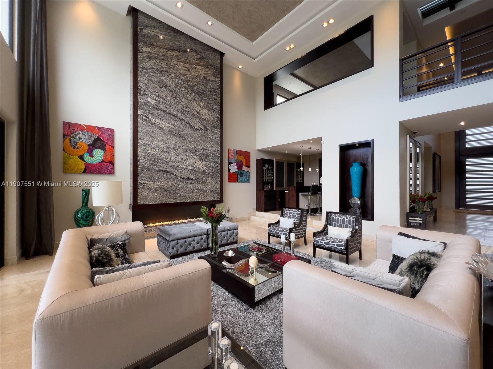 A spacious living room features a tall stone fireplace, neutral sofas, and a mirrored coffee table — Rincon Del Valle Cumbaya Quito, EC, EC