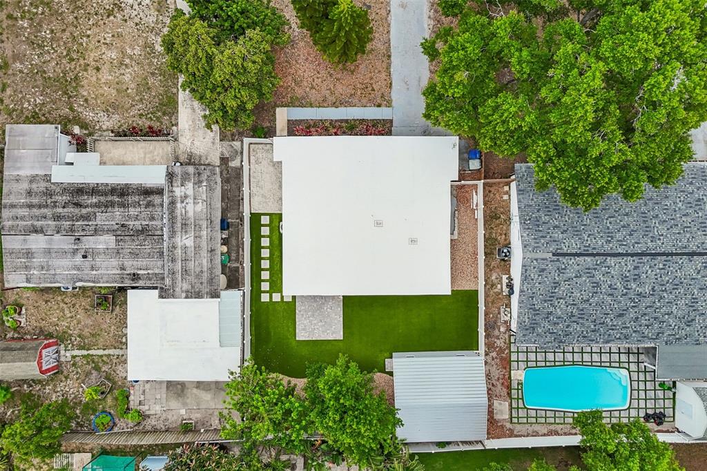 An aerial view shows a house with a flat white roof, artificial turf, and pool — 4114 W OLIVE STREET, TAMPA, FL