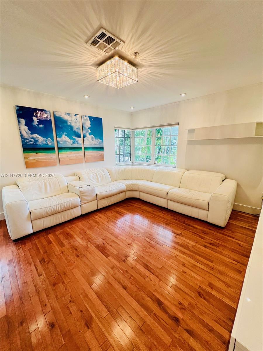 A living room features a large white sectional sofa, hardwood floors, and wall art — 600 Euclid Ave # 5B, Miami Beach FL 33139, MIAMI BEACH, FL