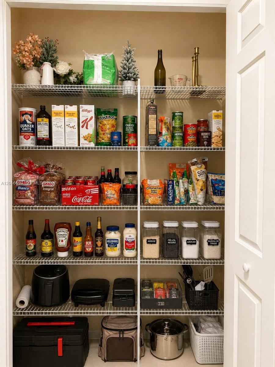A well-organized pantry features white wire shelving stocked with various food items and small appliances — 9845 NW 86th Ter, Doral FL 33178, DORAL, FL