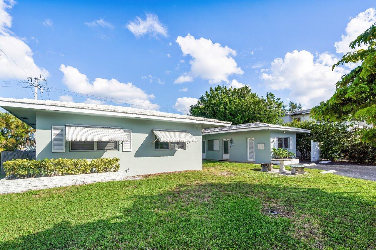 A single-story light green house with a flat roof and metal awnings sits on grass — 262 SE 9th Avenue # 4, Deerfield Beach FL 33441, DEERFIELD BEACH, FL