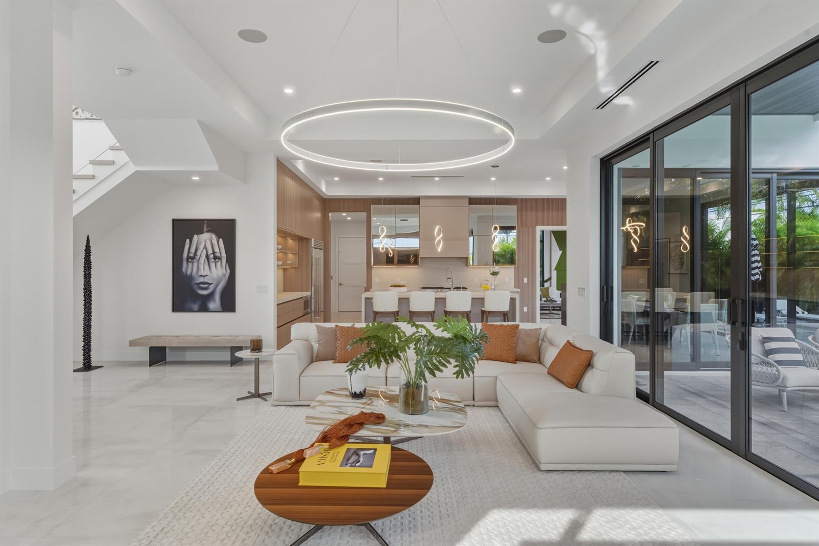 A modern open-concept living room features a white sectional sofa, marble coffee table, and kitchen — 1050 NE 3rd Avenue, Boca Raton FL 33432, BOCA RATON, FL