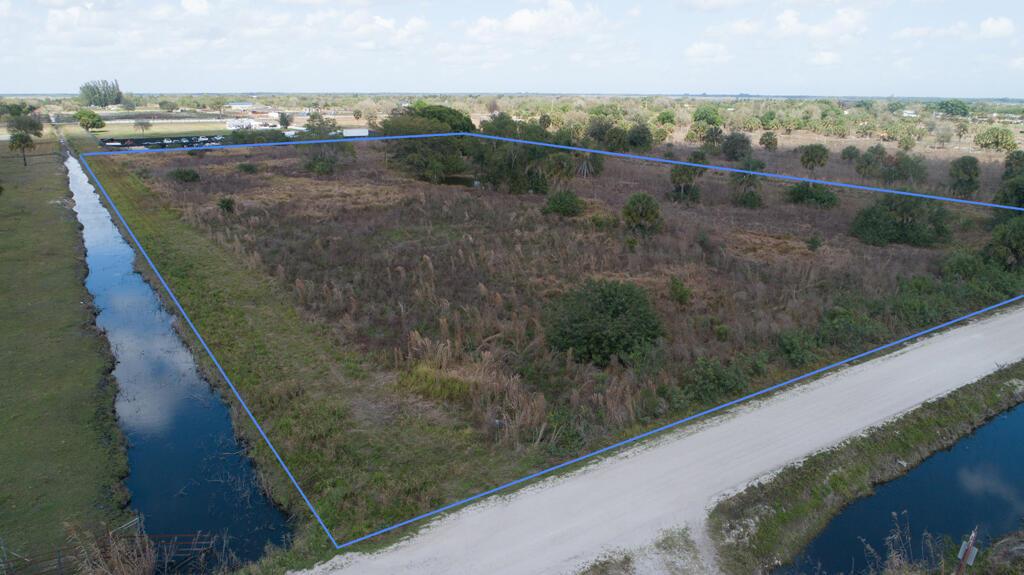 An aerial view shows a vacant, rectangular plot of land bordered by canals and a road — 20637 Simone Drive, Loxahatchee FL 33470, LOXAHATCHEE, FL
