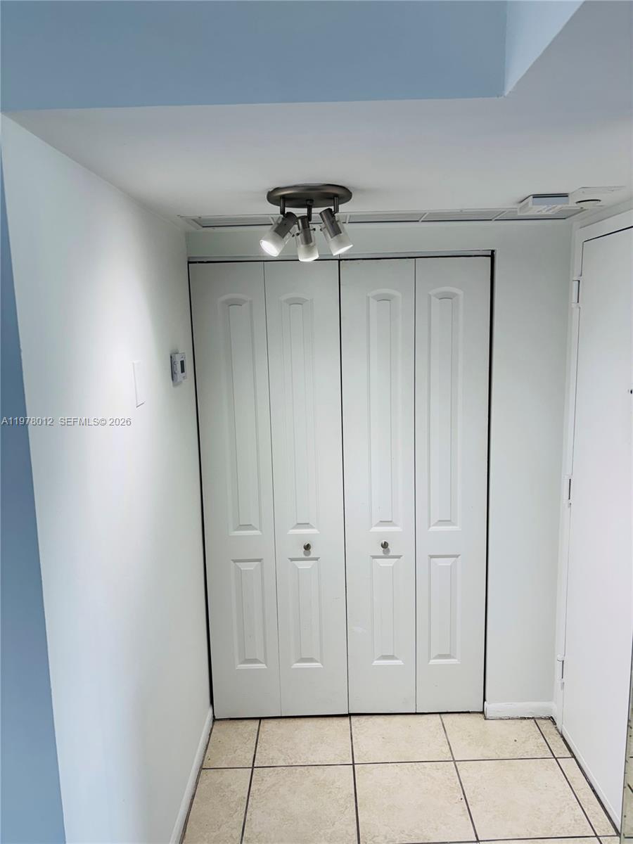 A small hallway features white bifold closet doors, tile flooring, and a ceiling light fixture — 2333 Brickell Ave # 1115, Miami FL 33129, MIAMI, FL