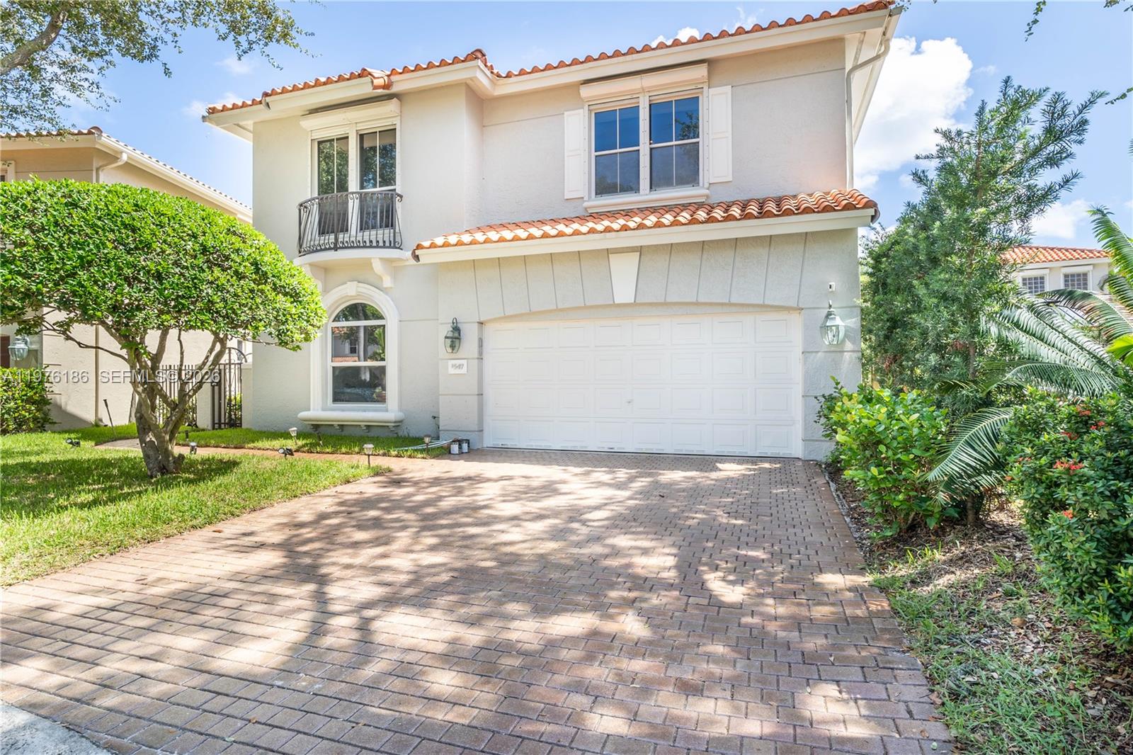A two-story house with a beige stucco exterior, a tiled roof, and a brick driveway — 1547 Mariner Way, Hollywood FL 33019, HOLLYWOOD, FL