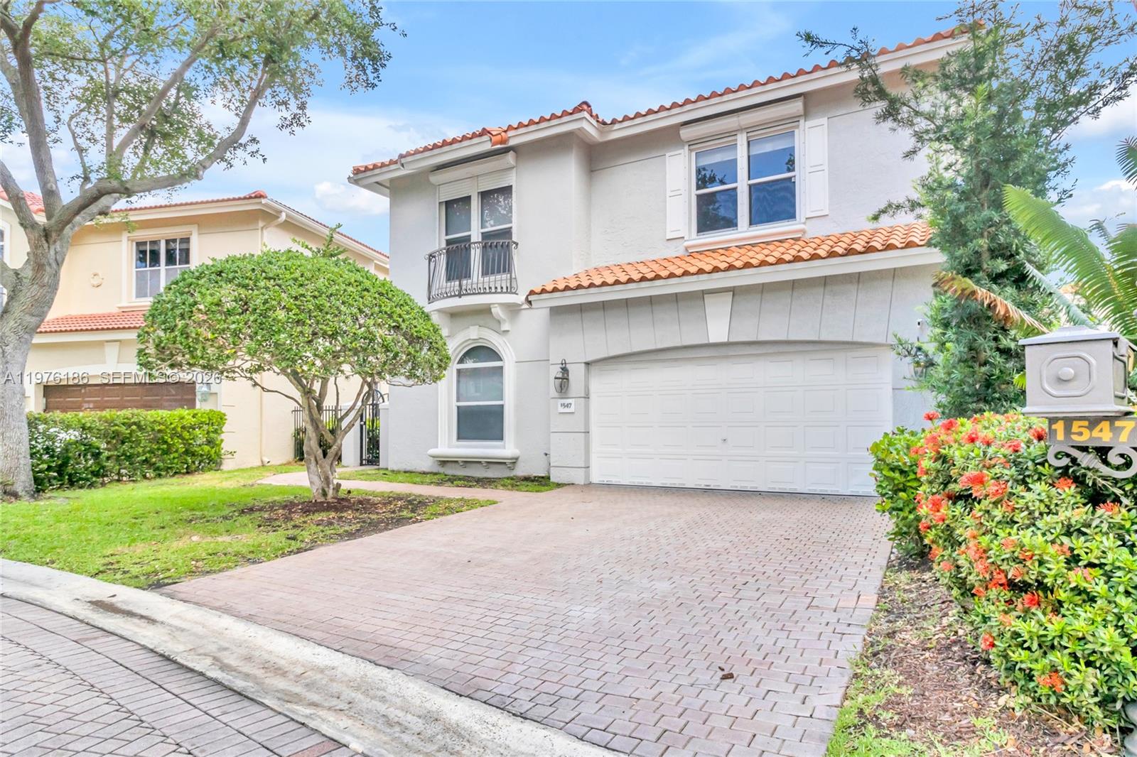 A two-story house with a white stucco exterior, a tiled roof, and a paved driveway — 1547 Mariner Way, Hollywood FL 33019, HOLLYWOOD, FL