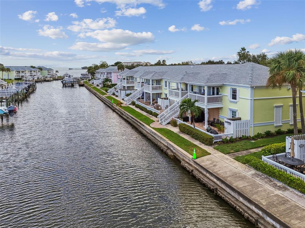An aerial view of waterfront townhomes with balconies along a canal lined with boat slips — 5116 BEACH DRIVE SE UNIT D, ST PETERSBURG, FL