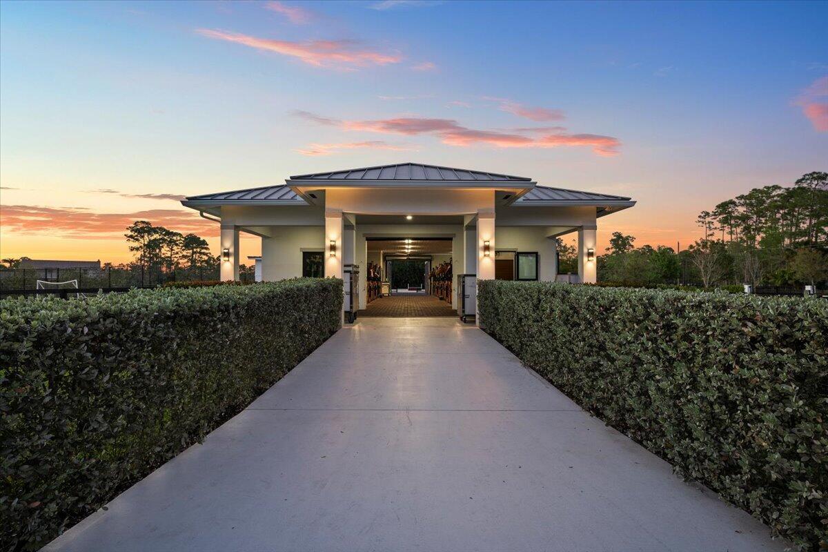A concrete driveway leads to the entrance of a modern stable building at sunset — 6209 Homeland Road, Lake Worth FL 33449, LAKE WORTH, FL