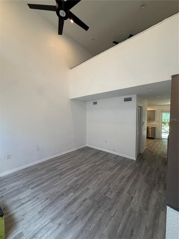 A living room with high ceilings, a ceiling fan, and light-colored wood-look flooring — 3924 CRAYRICH CIRCLE UNIT C5, ORLANDO, FL