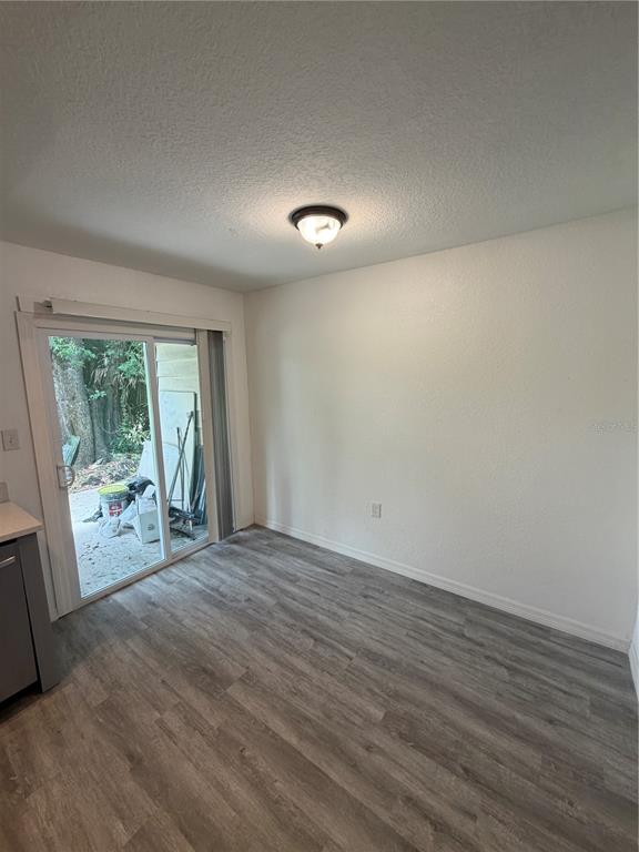 A dining area features gray wood-look flooring, a ceiling light, and a sliding glass door — 3924 CRAYRICH CIRCLE UNIT C5, ORLANDO, FL