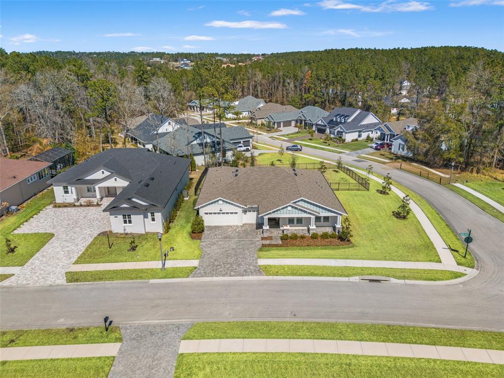 An aerial view shows two single-story suburban houses with paved driveways and lawns — 4698 HICKORY OAK DRIVE, BROOKSVILLE, FL
