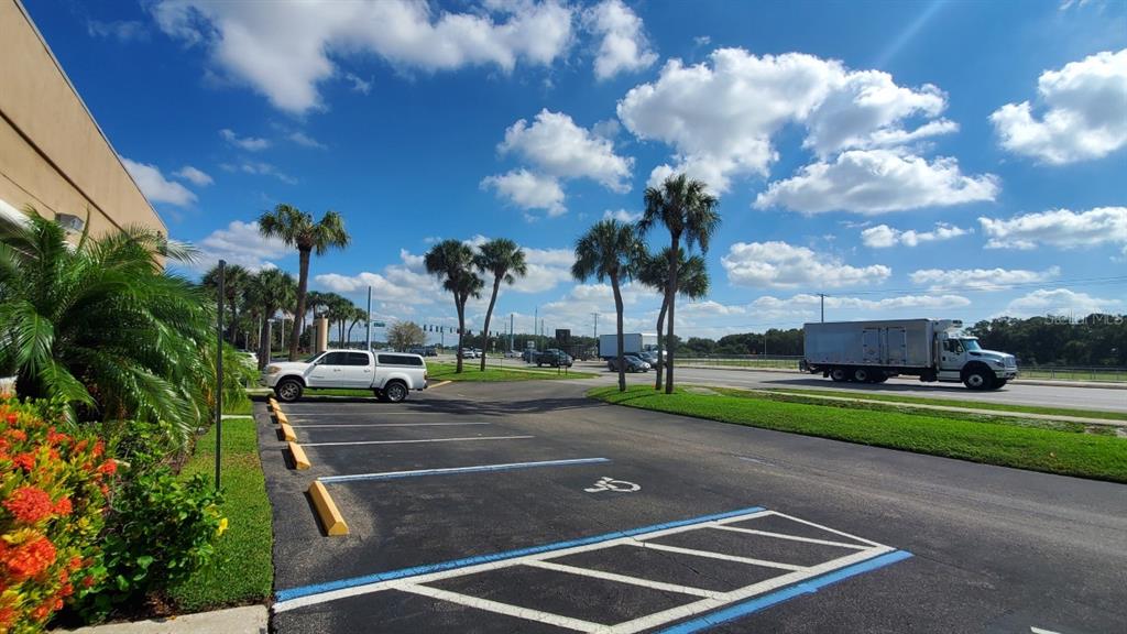 A parking lot with a handicap space, palm trees, and a truck on a nearby road — 5404 HOOVER BOULEVARD UNIT 5, TAMPA, FL