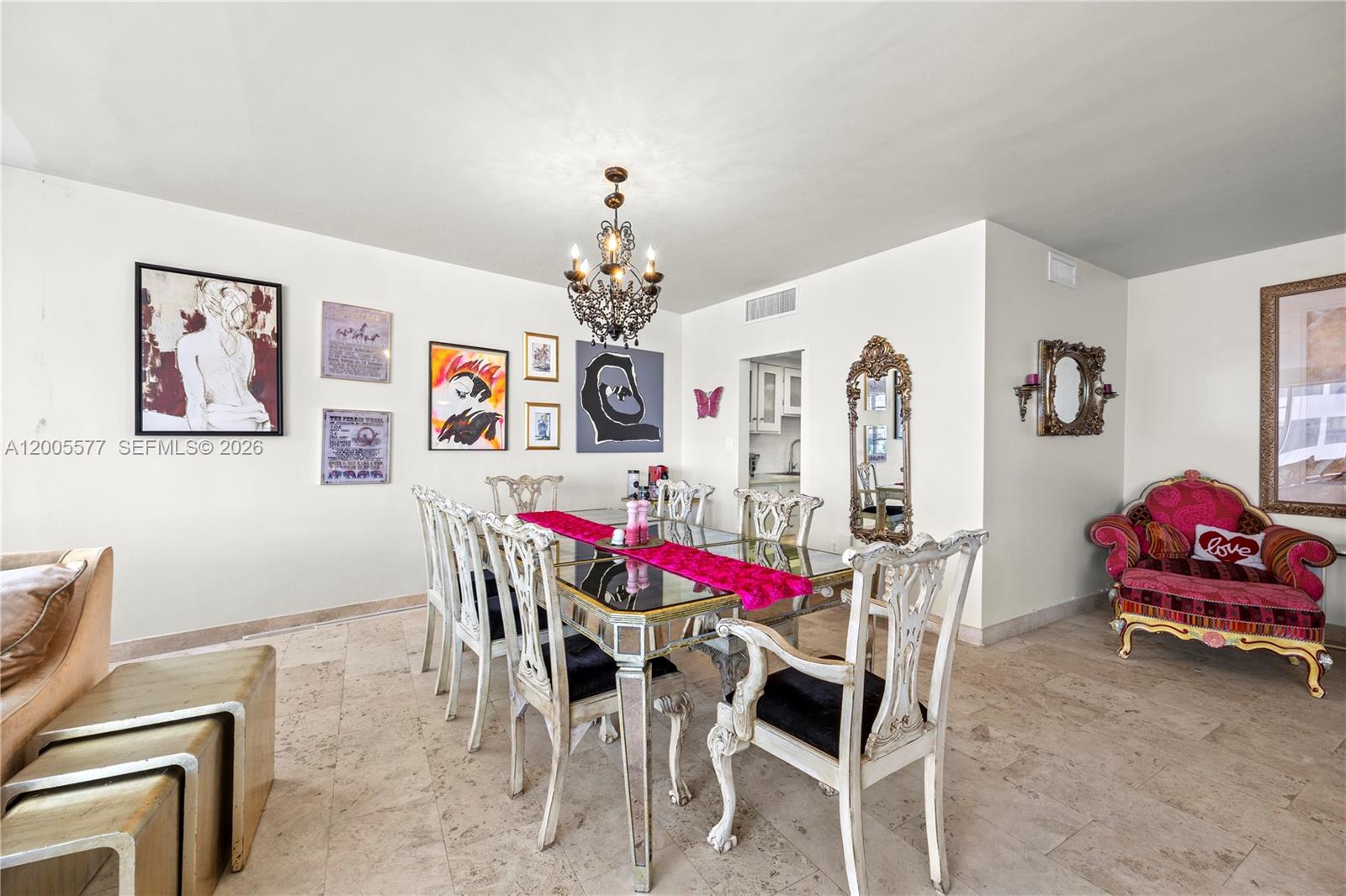 A dining room features a mirrored table, ornate white chairs, and a black chandelier — 5255 Collins Ave # 11A, Miami Beach FL 33140, MIAMI BEACH, FL