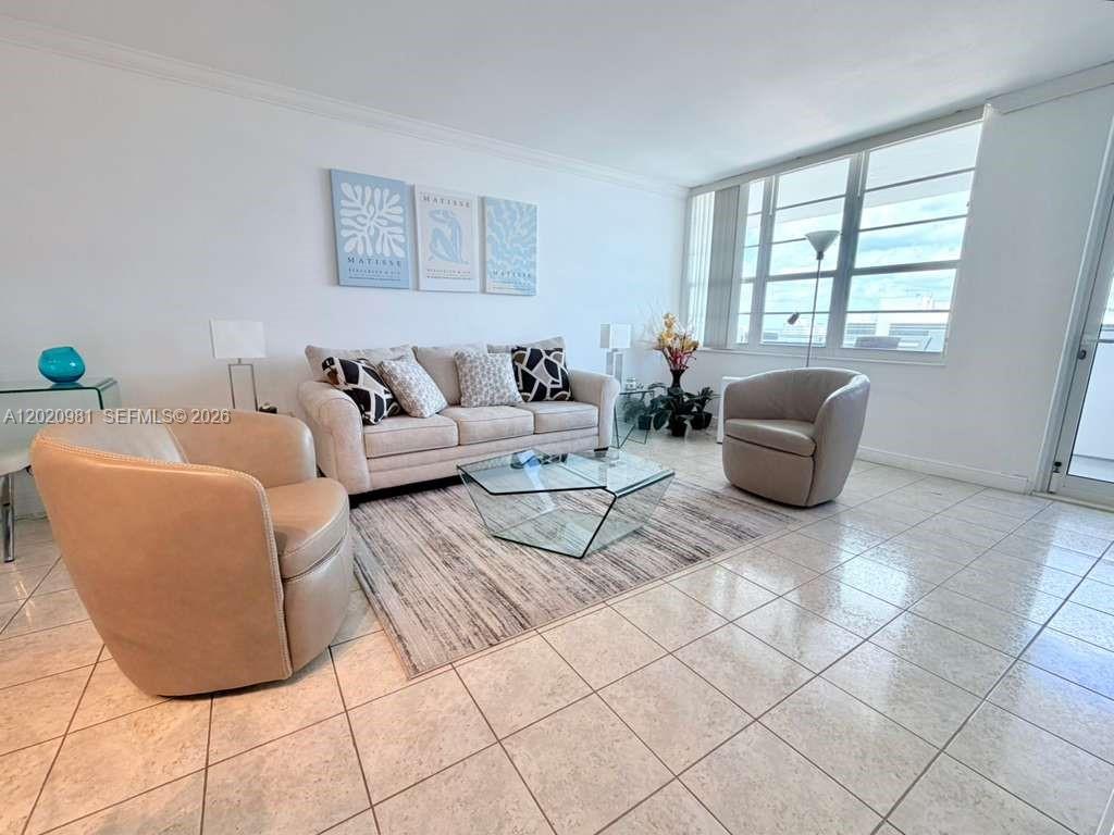 A living room features a beige sofa, two armchairs, a glass coffee table, and tile flooring — 100 Lincoln Rd # 1423, Miami Beach FL 33139, MIAMI BEACH, FL