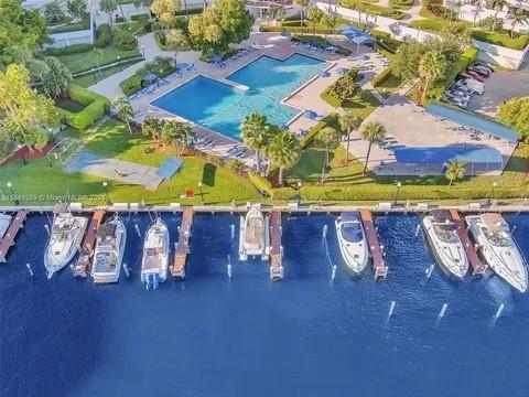 An aerial view shows a swimming pool, landscaped grounds, and boats docked at a pier — 2500 Parkview Drive # 814, Hallandale Beach FL 33009, HALLANDALE BEACH, FL