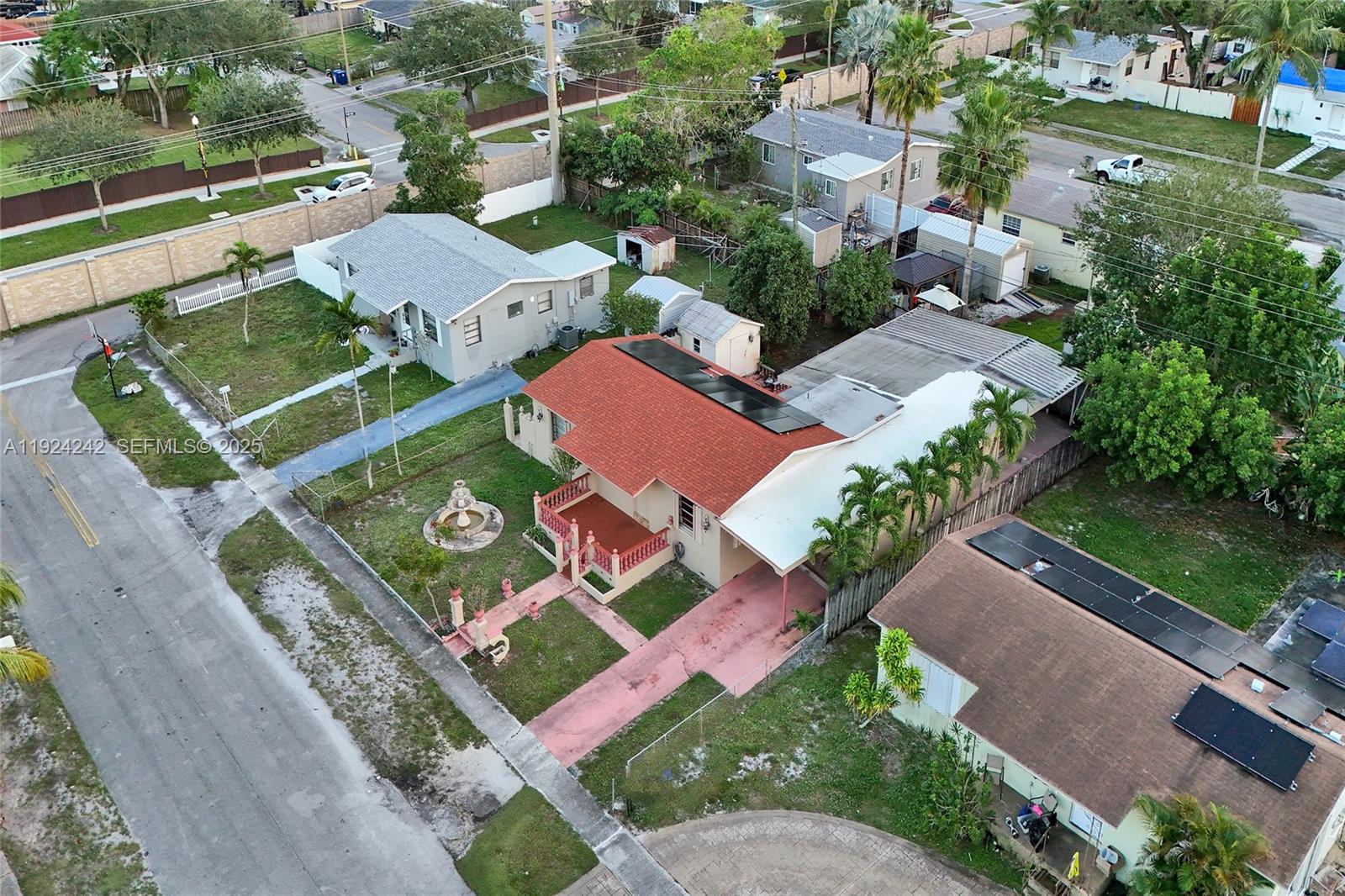 An aerial view shows a residential street with houses, yards, and solar panels on roofs — 6404 Evans St, Hollywood FL 33024, HOLLYWOOD, FL