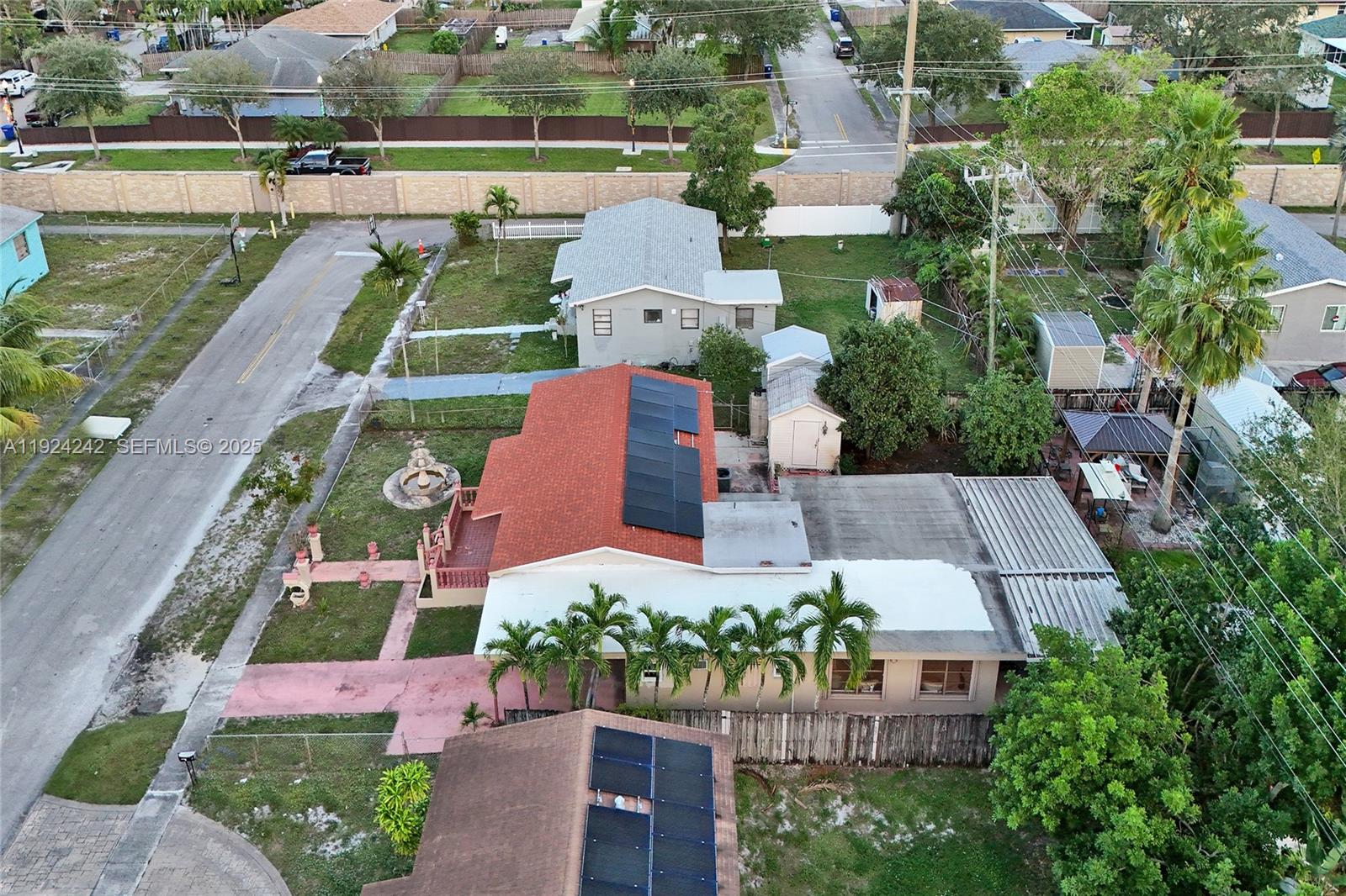 An aerial view shows a residential property with a red-roofed house featuring solar panels — 6404 Evans St, Hollywood FL 33024, HOLLYWOOD, FL