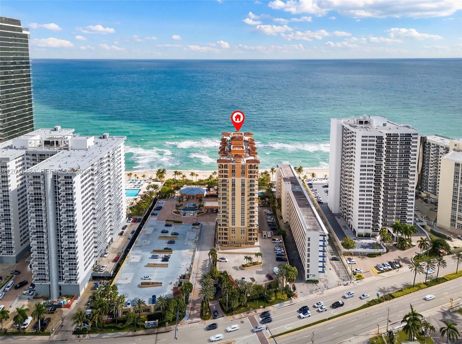 An aerial view shows a tall residential building on a beach with surrounding parking lots — 2080 S Ocean Dr # 1711, Hallandale Beach FL 33009, HALLANDALE BEACH, FL