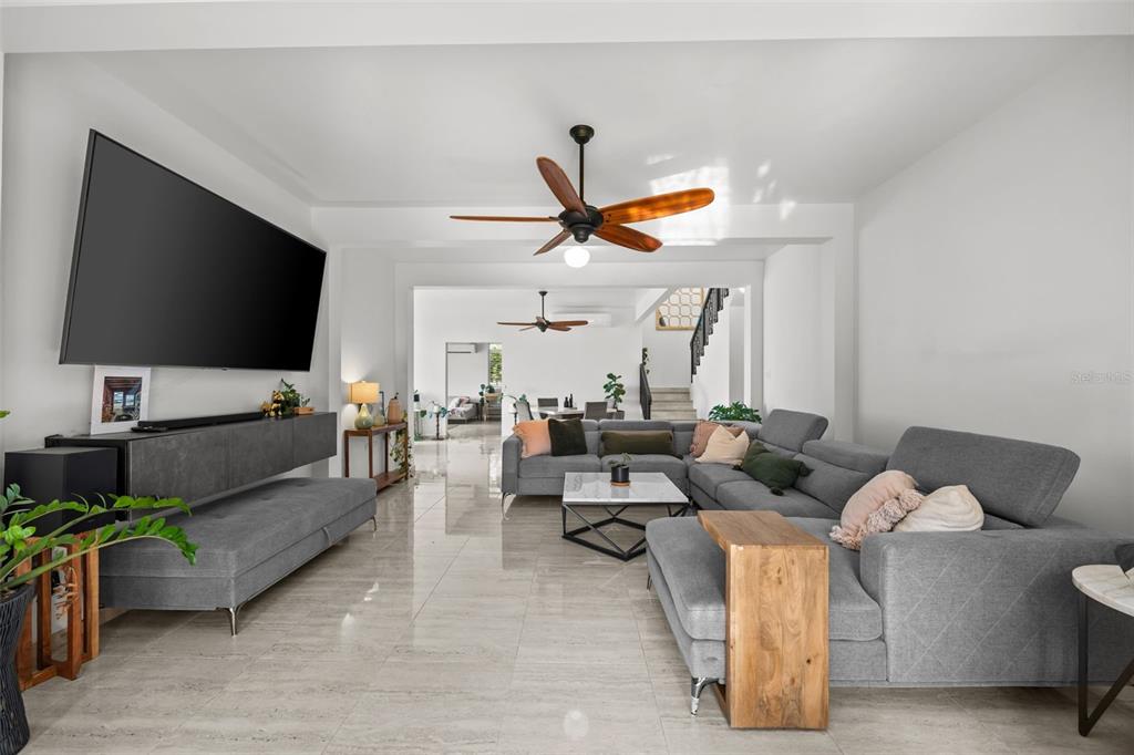 A modern living room features a large gray sectional, a wall-mounted television, and tile flooring — PR 466 ACUAMARINA UNIT KM 4.9, ISABELA, PR