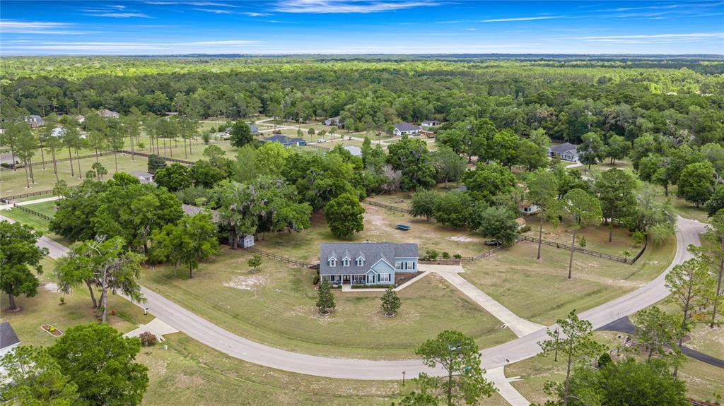 An aerial view shows a single-story house with a large yard surrounded by trees — 25162 NW 204TH PLACE, HIGH SPRINGS, FL
