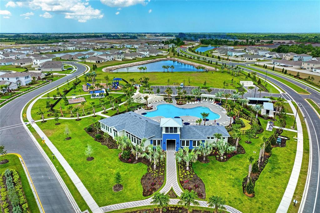 An aerial view of a community clubhouse with a swimming pool, playground, and surrounding homes — 10815 CHARLOTTE DRIVE, PARRISH, FL