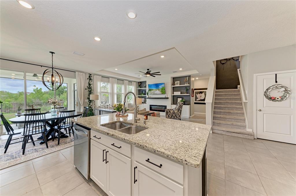 A kitchen island with granite countertops overlooks an open-concept living and dining area — 10815 CHARLOTTE DRIVE, PARRISH, FL