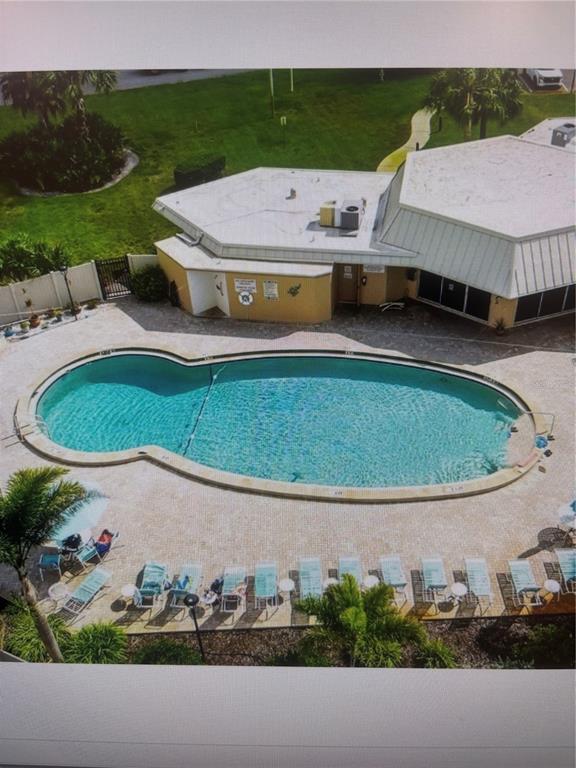An aerial view shows a swimming pool with a unique shape next to a building — 4210 IRONWOOD CIRCLE UNIT 404J, BRADENTON, FL
