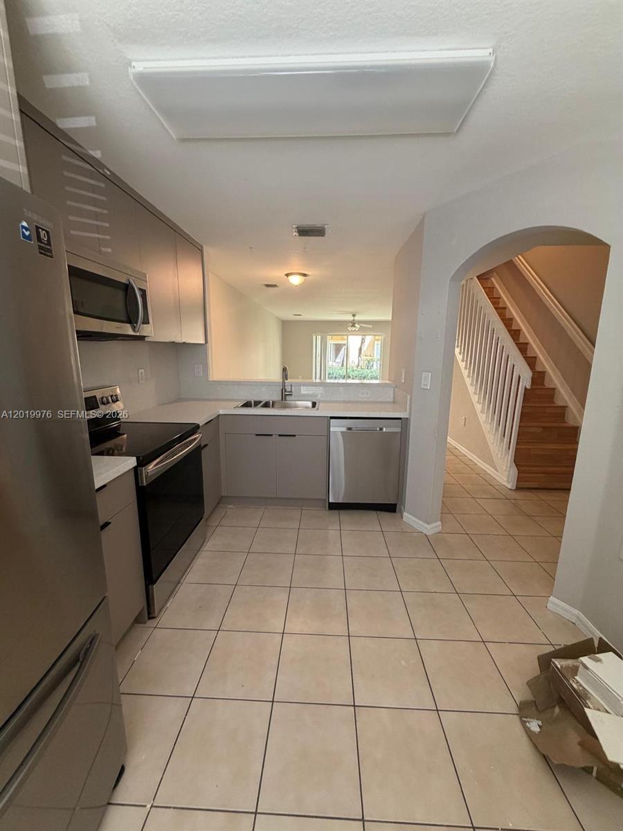 A kitchen with stainless steel appliances, light gray cabinets, and tile flooring — 3023 SW 129th Ter # 155, Miramar FL 33027, MIRAMAR, FL