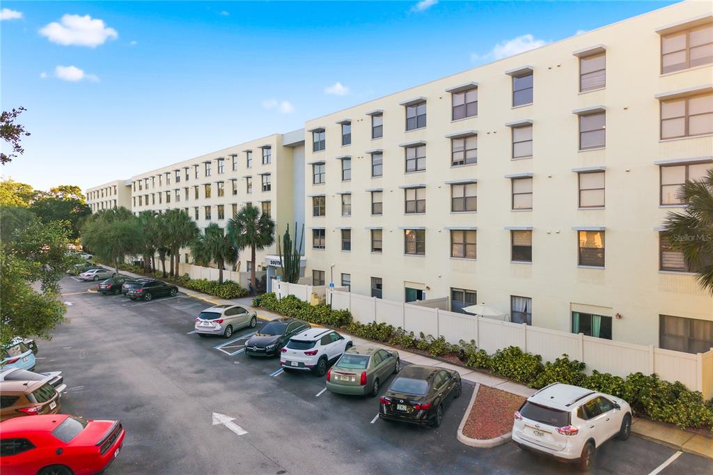 An exterior view of a multi-story apartment building with a parking lot in front — 701 S MADISON AVENUE UNIT 420, CLEARWATER, FL
