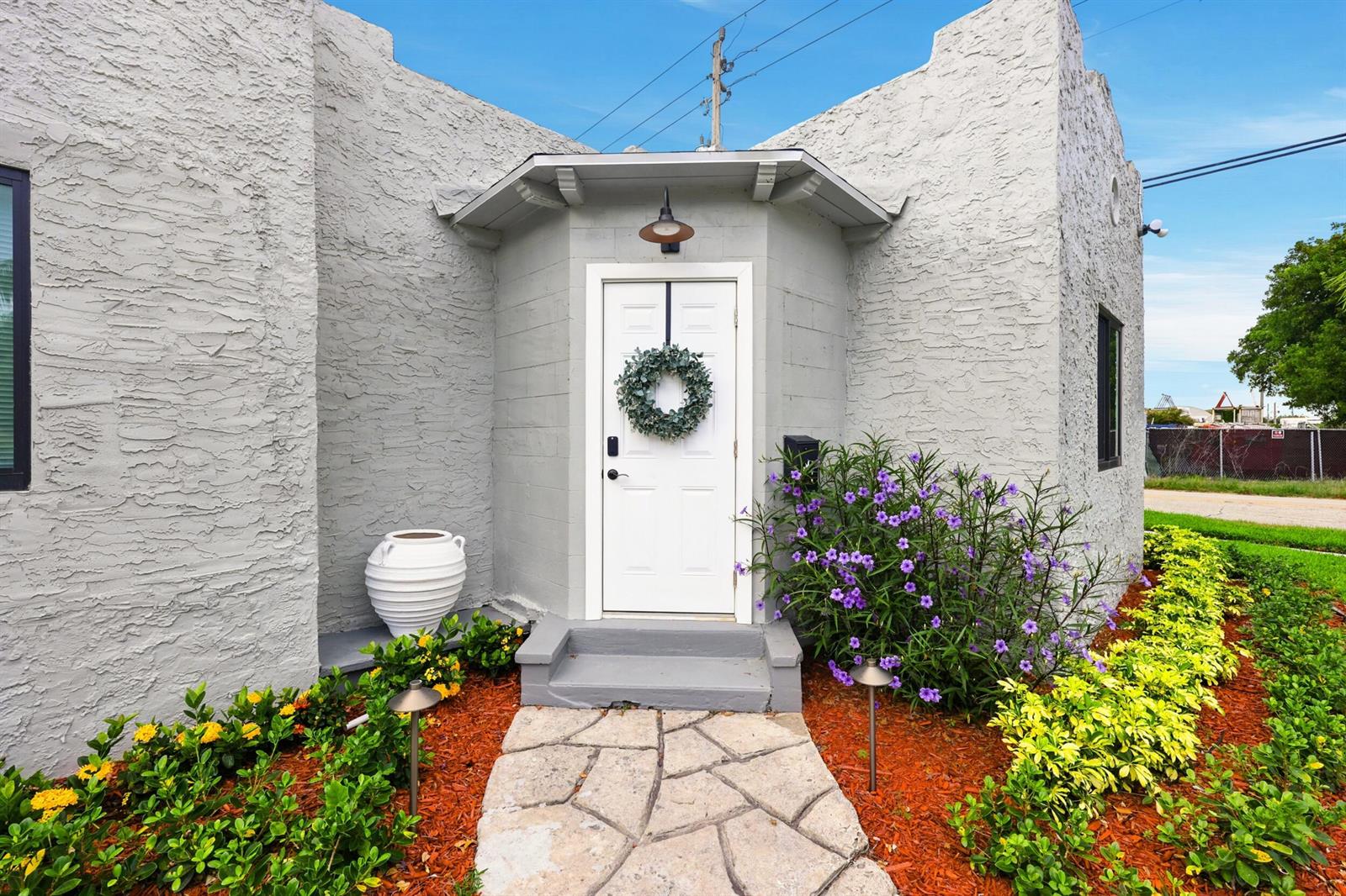 The exterior of a gray stucco building features a white front door with a wreath — 424 Putnam Road, West Palm Beach FL 33405, WEST PALM BEACH, FL