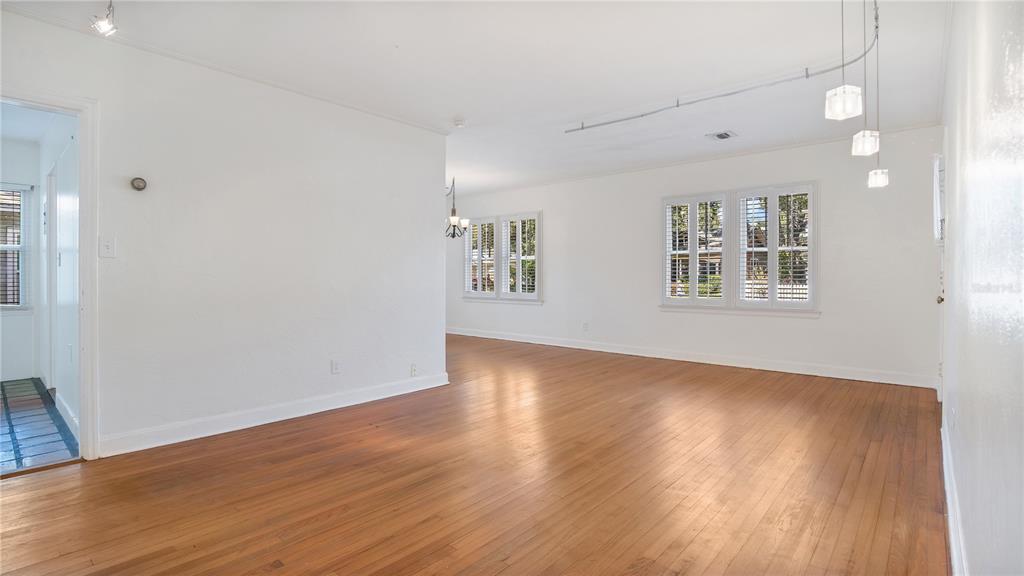An empty living room features hardwood floors, white walls, and windows with plantation shutters — 2 W YALE STREET, ORLANDO, FL