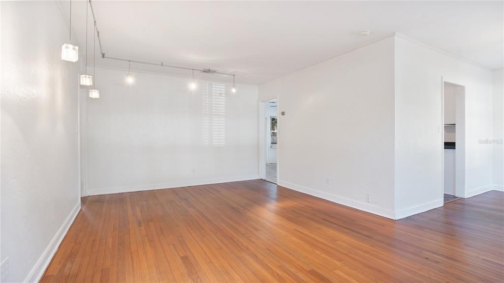 An empty room with hardwood floors, white walls, and a track lighting system — 2 W YALE STREET, ORLANDO, FL