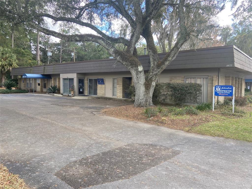 A single-story commercial building with a large tree in front and a parking lot — 1405 NW 13TH STREET UNIT B, GAINESVILLE, FL