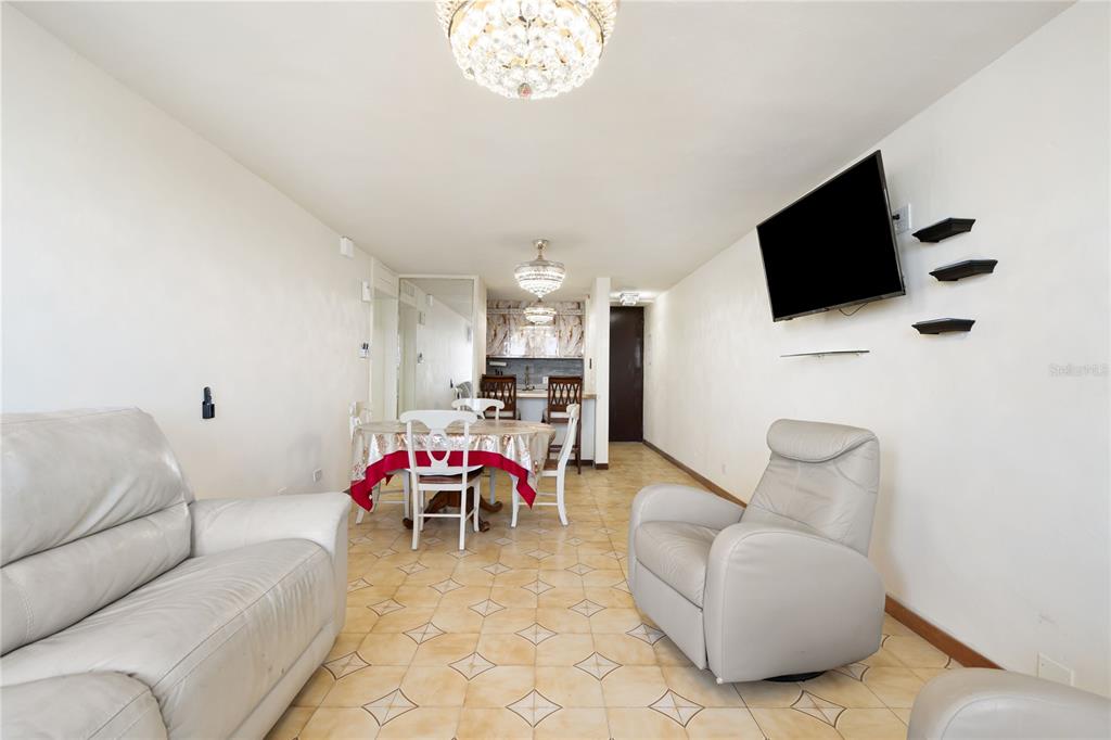 A living and dining area features light-colored tile floors, white walls, and two crystal chandeliers — 801 CANGREJO ARRIBA UNIT 801 A, CAROLINA, PR