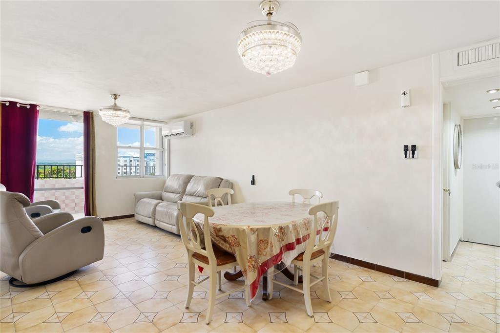 A living and dining area features tile flooring, two crystal chandeliers, and a balcony view — 801 CANGREJO ARRIBA UNIT 801 A, CAROLINA, PR
