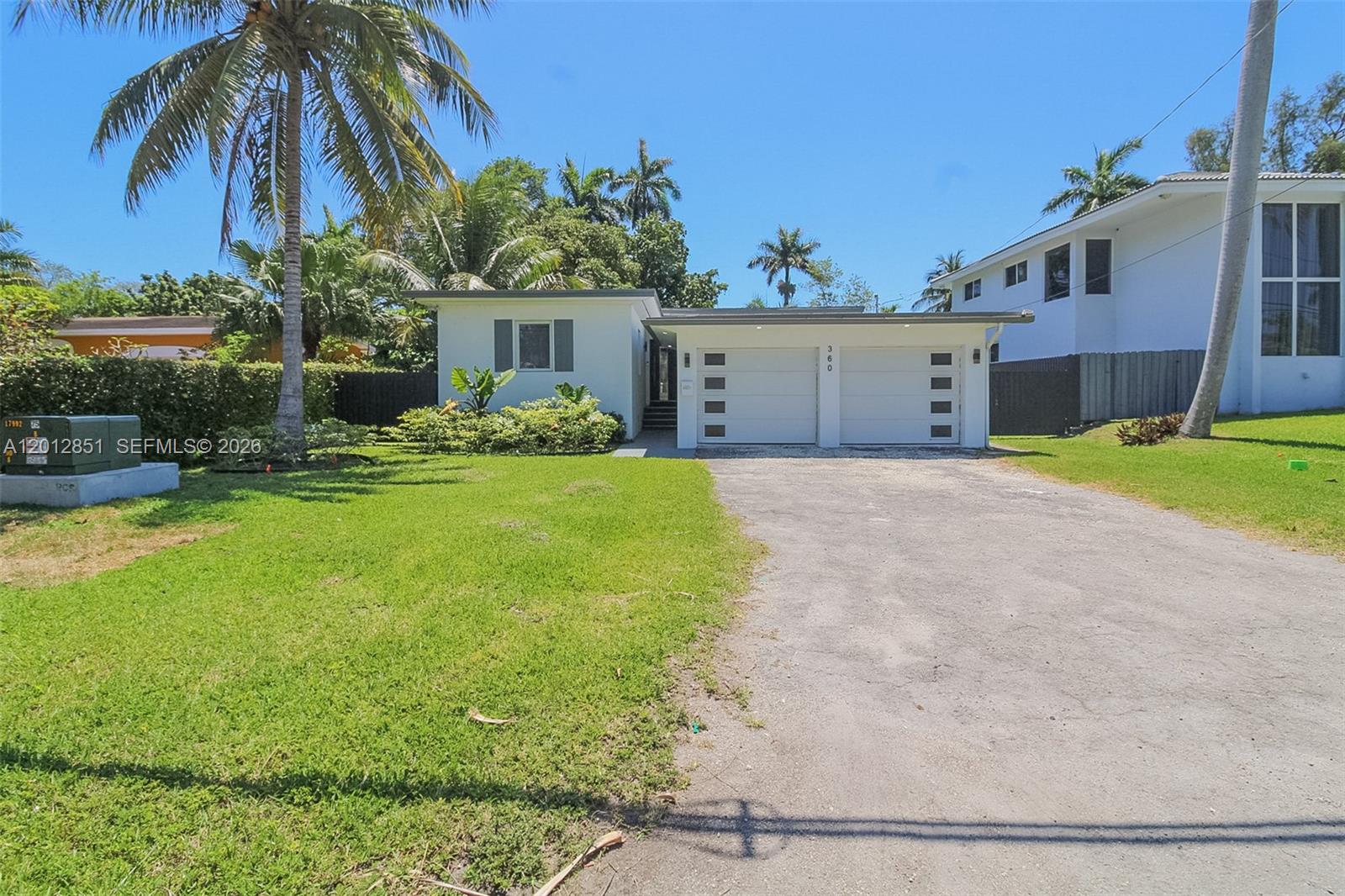 A single-story white house with a two-car garage and a palm tree-lined front yard — 360 NE 116th ST, Miami FL 33161, MIAMI, FL