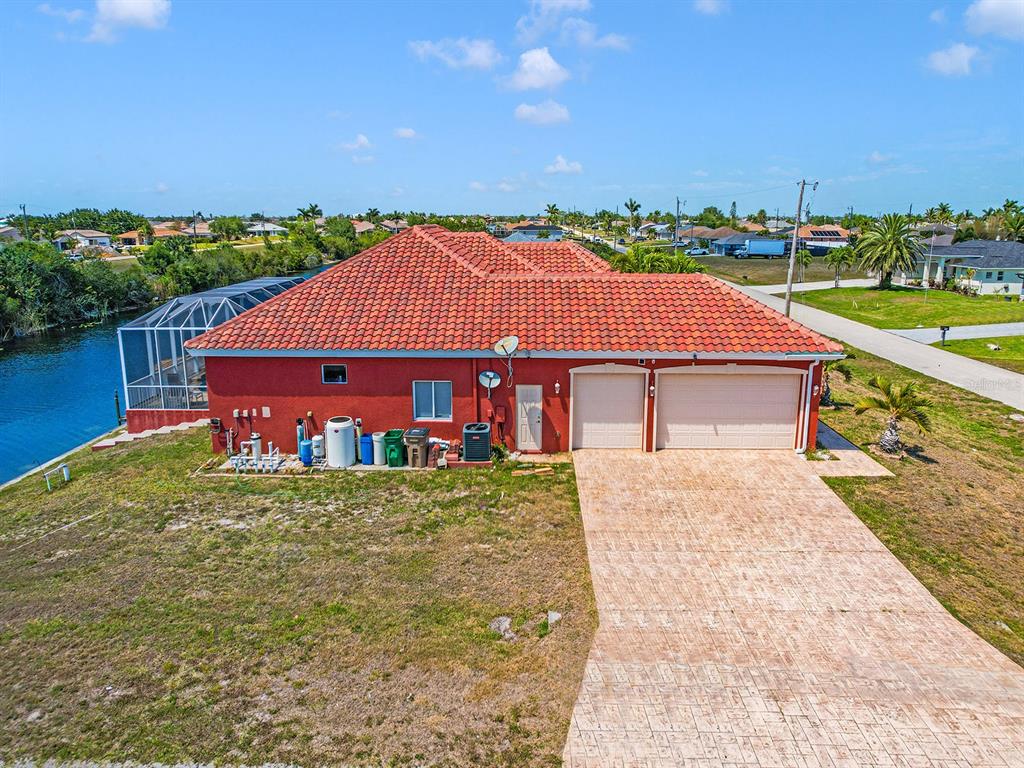 An aerial view of a red house with a tiled roof and a two-car garage — 1112 NW 9TH AVENUE, CAPE CORAL, FL