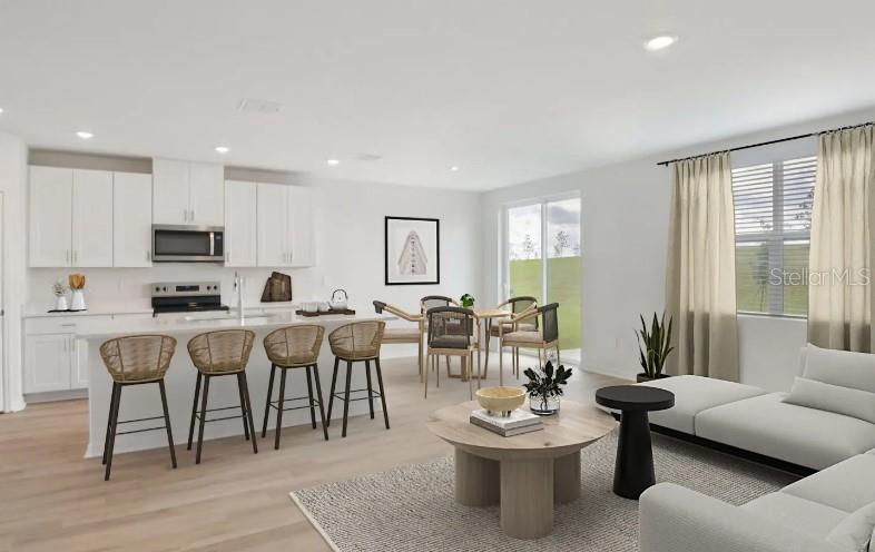 This is a digital rendering of an open-concept kitchen, dining area, and living room — 12562 HOURGLASS WAY, DADE CITY, FL