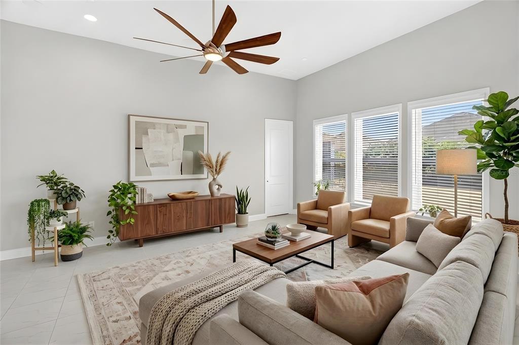 A living room features a wooden console, two leather armchairs, a sofa, and a ceiling fan — 11943B SW 31ST ROAD, GAINESVILLE, FL