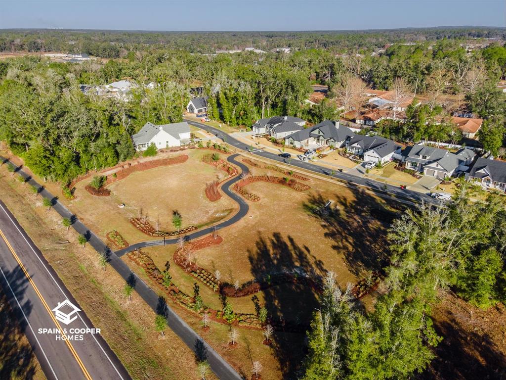 An aerial view shows a winding paved path through a grassy lot near suburban houses — 761 SW 139TH COURT, NEWBERRY, FL