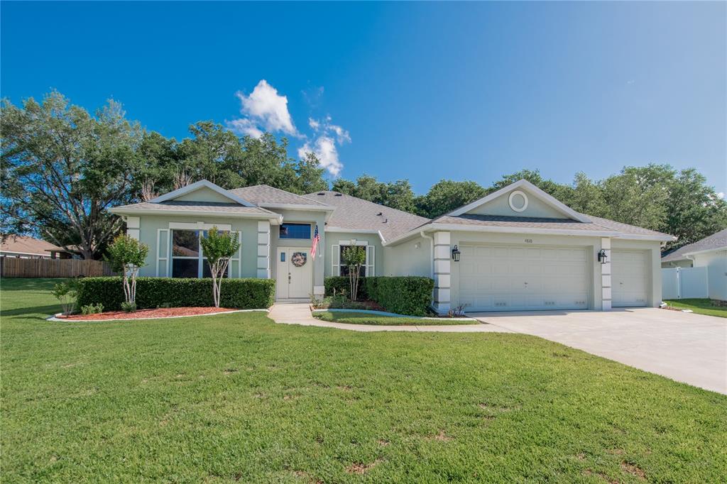 A bright entryway features a white front door, a potted tree, and a console table — 4810 WATER LARK WAY, VALRICO, FL