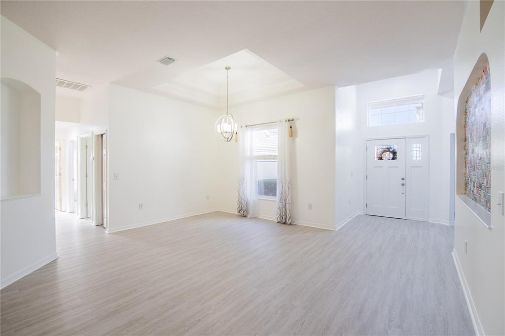 A home office features a wooden desk, a rolling chair, and a window with blue curtains — 4810 WATER LARK WAY, VALRICO, FL