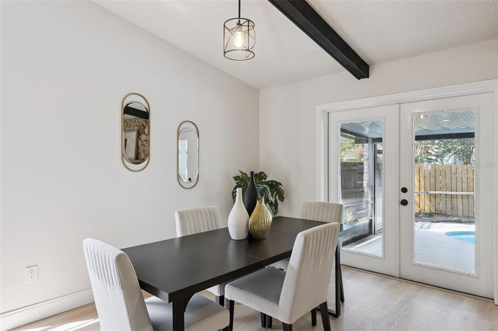 A dining room features a dark table, four chairs, two oval mirrors, and glass doors — 1454 KING COURT, WINTER SPRINGS, FL