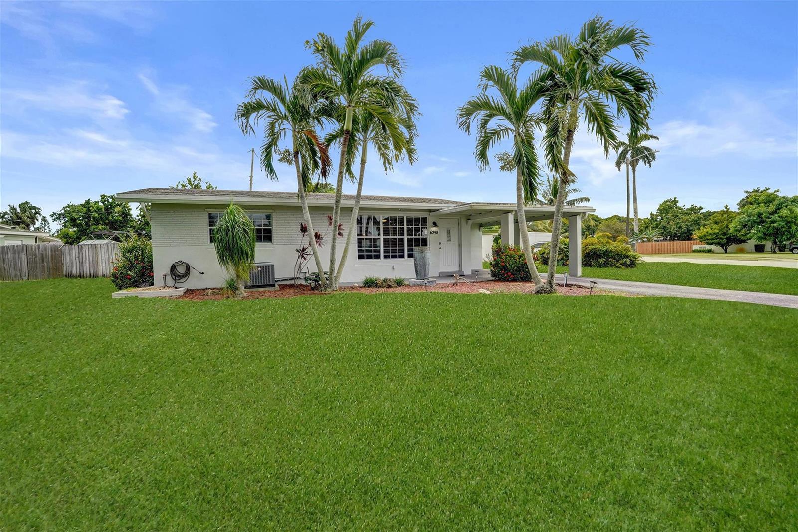 A single-story house with a white brick exterior, palm trees, and a front lawn — 6298 NW 15th Street, Margate FL 33063, MARGATE, FL