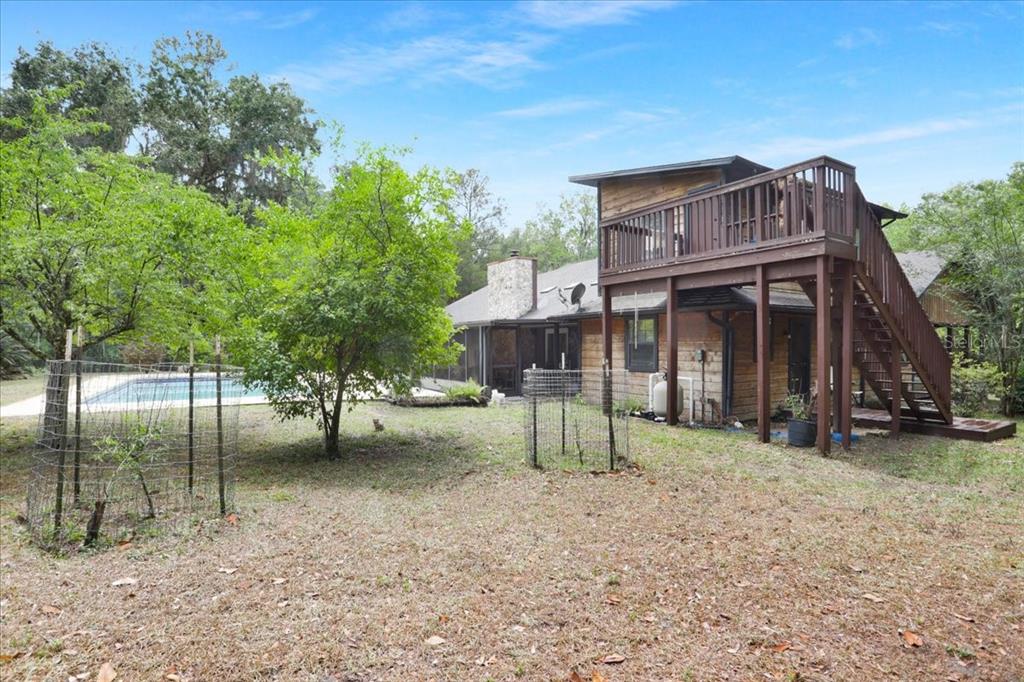 A two-story wooden house with a garage and a wooden playset in the yard — 22731 NW 91ST COURT ROAD, MICANOPY, FL